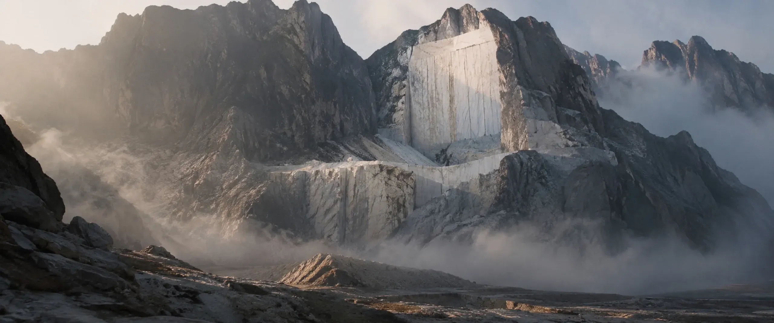 A marble quarry in mist — the white wall of blocks inside the mountain